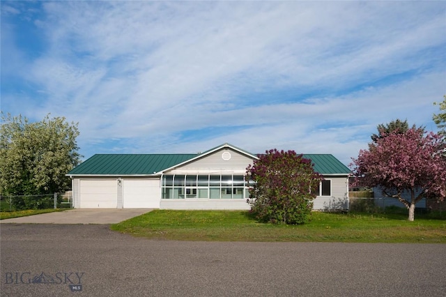 607 N Hoffman St, Belgrade, MT 59714 - single story home with driveway, an attached garage, metal roof, a front lawn, and a standing seam roof