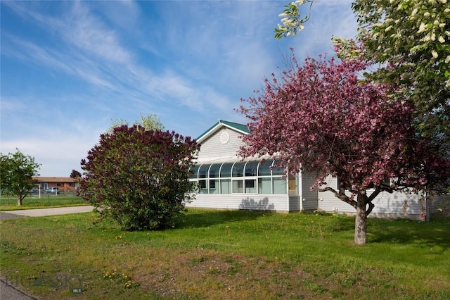 607 N Hoffman St, Belgrade, MT 59714 - view of property exterior featuring a lawn and a sunroom