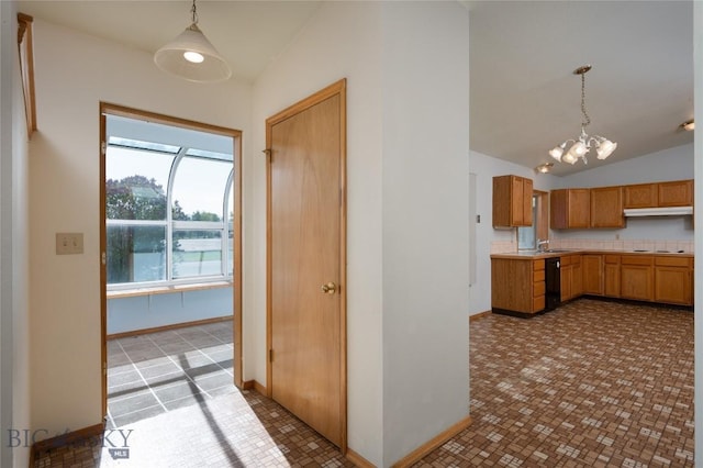 607 N Hoffman St, Belgrade, MT 59714 - kitchen featuring vaulted ceiling, a chandelier, light countertops, decorative light fixtures, and baseboards