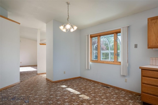 607 N Hoffman St, Belgrade, MT 59714 - unfurnished dining area with a chandelier and baseboards