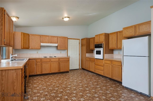 607 N Hoffman St, Belgrade, MT 59714 - kitchen with white appliances, a sink, under cabinet range hood, high vaulted ceiling, and tile countertops