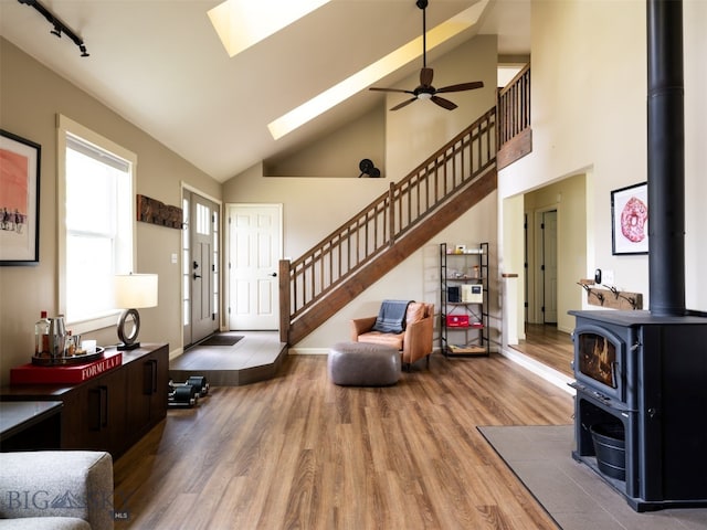 507 Flathead Ave, Bozeman, MT 59718 - living room featuring a wood stove, stairs, wood finished floors, a skylight, and a ceiling fan