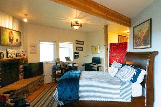 202 Beach Dr, West Yellowstone, MT 59758 - bedroom featuring a fireplace with raised hearth, an office area, and wood finished floors