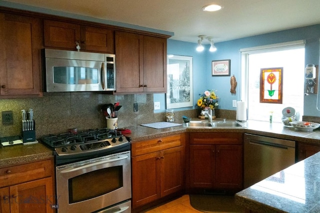 202 Beach Dr, West Yellowstone, MT 59758 - kitchen featuring stainless steel appliances, a sink, brown cabinets, backsplash, and recessed lighting