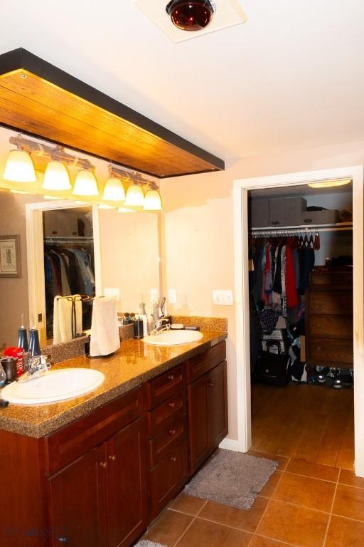202 Beach Dr, West Yellowstone, MT 59758 - bathroom featuring tile patterned floors, double vanity, and a walk in closet