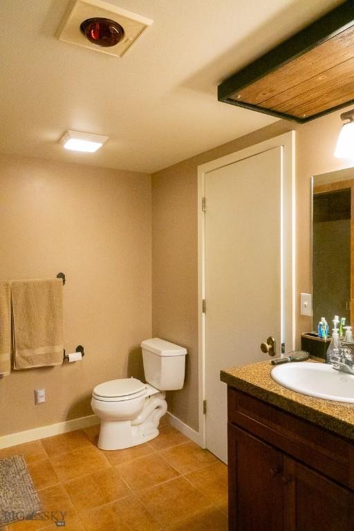 202 Beach Dr, West Yellowstone, MT 59758 - bathroom featuring vanity, baseboards, toilet, and tile patterned floors