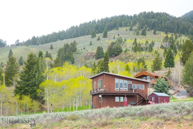 202 Beach Dr, West Yellowstone, MT 59758 - back of house featuring stairs, a wooden deck, and a forest view