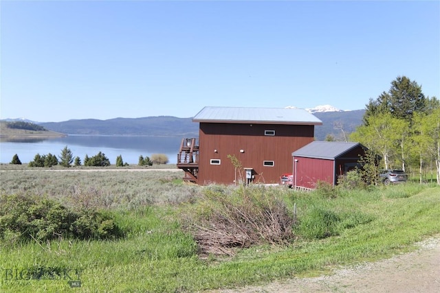 202 Beach Dr, West Yellowstone, MT 59758 - view of side of home featuring a water and mountain view, metal roof, and an outdoor structure