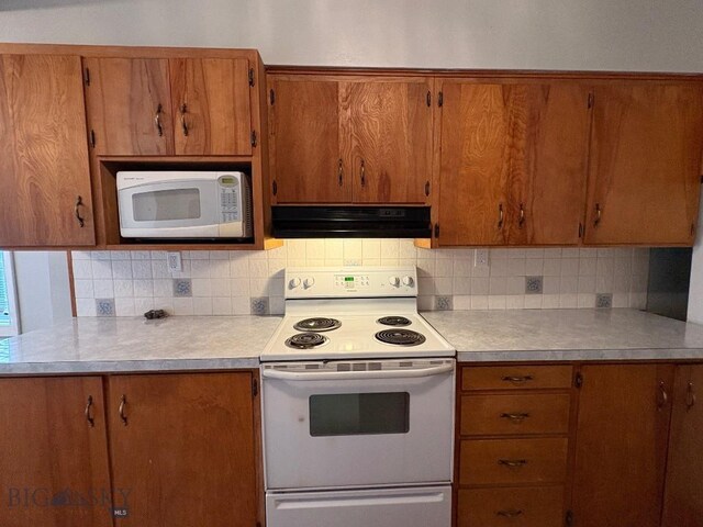 330 N Walnut St, Dillon, MT 59725 - kitchen with white appliances, under cabinet range hood, decorative backsplash, and light countertops