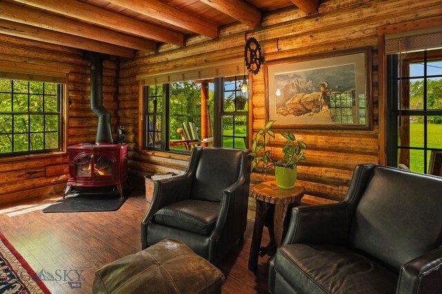 25 Big Chief Trl, Bozeman, MT 59718 - living area featuring a wood stove, wood-type flooring, rustic walls, and a wooden ceiling with exposed beams