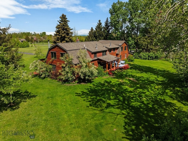 25 Big Chief Trl, Bozeman, MT 59718 - rear view of property featuring a gambrel roof, a yard, view of wooded area, and a chimney