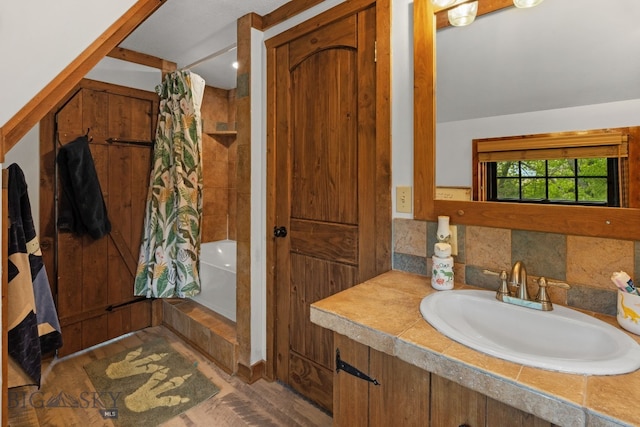 25 Big Chief Trl, Bozeman, MT 59718 - bathroom featuring shower / bath combo, wood finished floors, vanity, and decorative backsplash