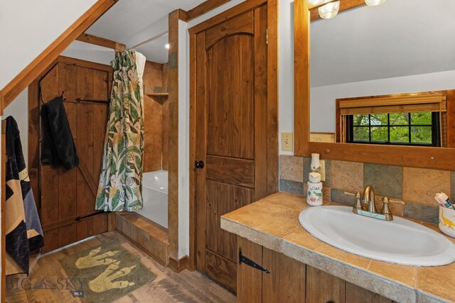 25 Big Chief Trl, Bozeman, MT 59718 - full bathroom featuring tiled shower / bath, wood finished floors, vanity, and tasteful backsplash