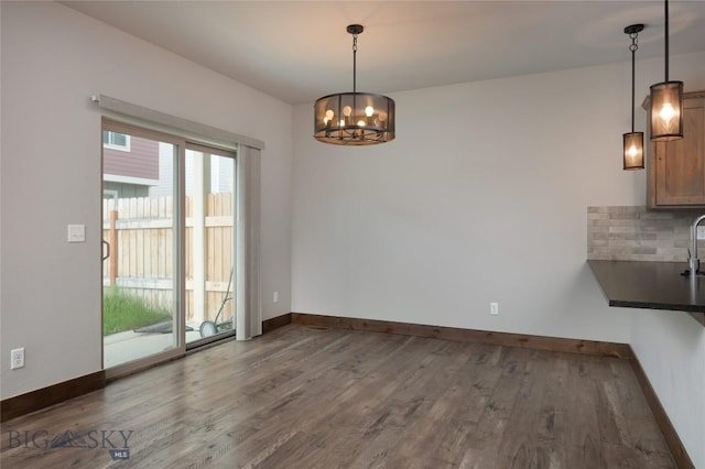 1304 Glider Ln Unit B, Belgrade, MT 59714 - unfurnished dining area with wood finished floors, a chandelier, and baseboards