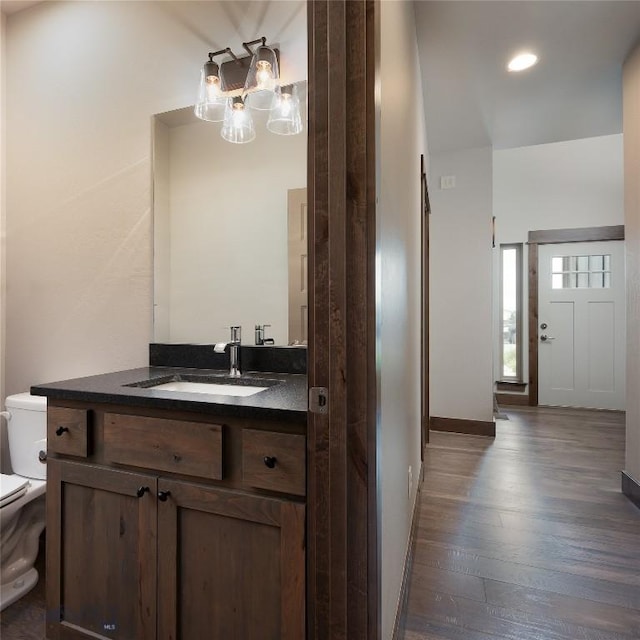 1304 Glider Ln Unit B, Belgrade, MT 59714 - bathroom with wood finished floors, toilet, a chandelier, vanity, and recessed lighting