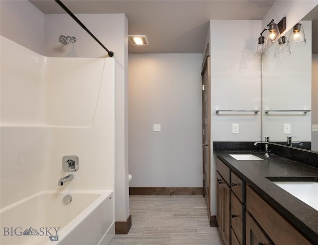 1304 Glider Ln Unit B, Belgrade, MT 59714 - full bathroom with shower / bathtub combination, baseboards, wood finished floors, double vanity, and toilet