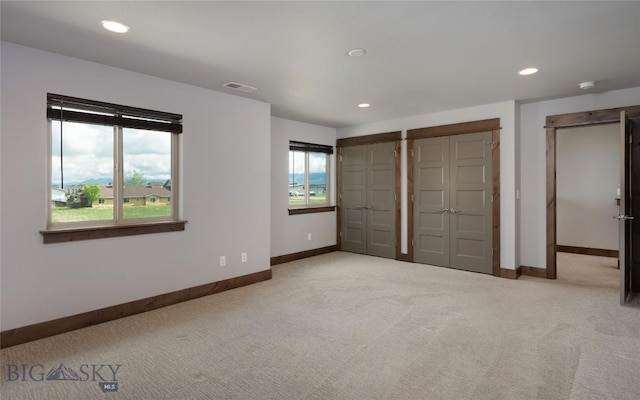 1304 Glider Ln Unit B, Belgrade, MT 59714 - unfurnished bedroom featuring light carpet, baseboards, two closets, and recessed lighting