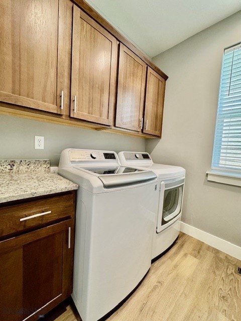 920 Butler Creek Ave, Belgrade, MT 59714 - laundry area featuring independent washer and dryer, cabinet space, light wood finished floors, and baseboards