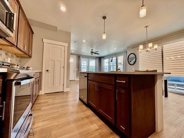 920 Butler Creek Ave, Belgrade, MT 59714 - kitchen with stainless steel appliances, light wood-style flooring, recessed lighting, decorative light fixtures, and a center island