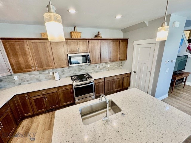 920 Butler Creek Ave, Belgrade, MT 59714 - kitchen featuring appliances with stainless steel finishes, a sink, decorative backsplash, decorative light fixtures, and recessed lighting