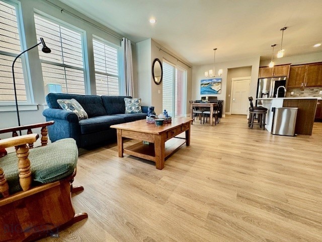 920 Butler Creek Ave, Belgrade, MT 59714 - living room featuring light wood-style floors and a chandelier