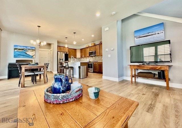 920 Butler Creek Ave, Belgrade, MT 59714 - living room featuring a chandelier, baseboards, light wood-style floors, and recessed lighting