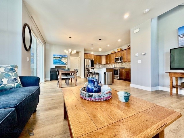 920 Butler Creek Ave, Belgrade, MT 59714 - dining room featuring a chandelier, light wood-style flooring, baseboards, and recessed lighting