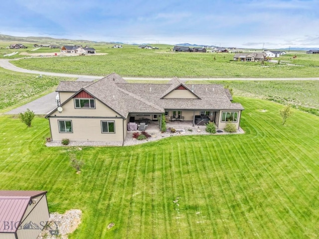 43 Lewis Dr, Three Forks, MT 59752 - rear view of house featuring a patio, a lawn, and roof with shingles