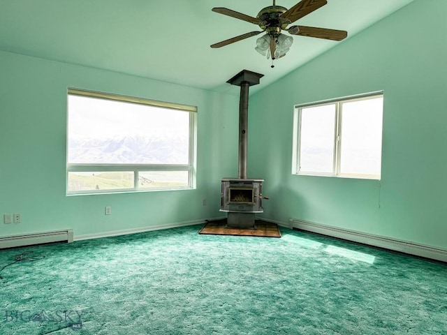 263 Hercules Rd, Emigrant, MT 59027 - unfurnished living room featuring lofted ceiling, a wood stove, carpet, a baseboard heating unit, and a ceiling fan