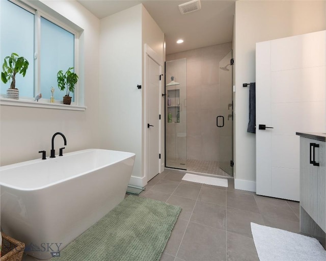 1510 Windrow Dr, Bozeman, MT 59718 - bathroom featuring a shower stall, a freestanding bath, tile patterned flooring, baseboards, and recessed lighting
