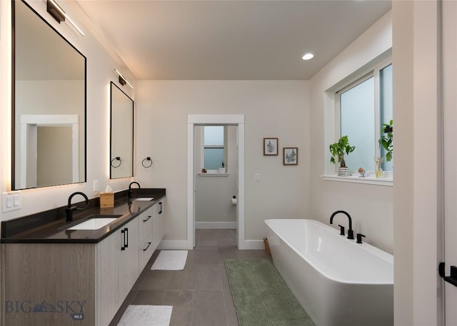 1510 Windrow Dr, Bozeman, MT 59718 - full bathroom with a freestanding bath, baseboards, tile patterned flooring, double vanity, and recessed lighting
