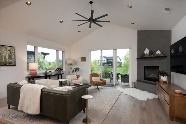 1510 Windrow Dr, Bozeman, MT 59718 - living room featuring high vaulted ceiling, wood finished floors, a ceiling fan, a tile fireplace, and recessed lighting