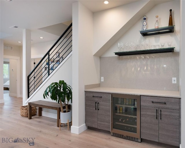 1510 Windrow Dr, Bozeman, MT 59718 - indoor dry bar with beverage cooler, light wood finished floors, stairway, tasteful backsplash, and recessed lighting