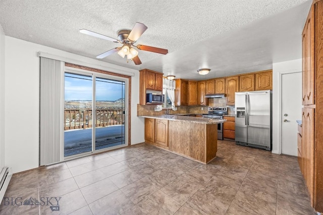 34 Mammoth, Butte, MT 59701 - kitchen with stainless steel appliances, a peninsula, brown cabinets, a ceiling fan, and a textured ceiling