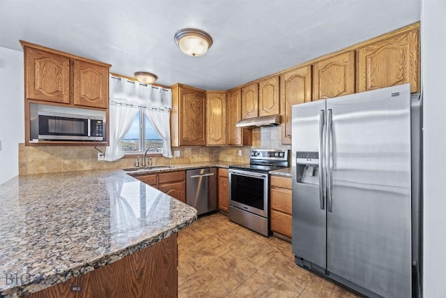34 Mammoth, Butte, MT 59701 - kitchen with stainless steel appliances, a sink, under cabinet range hood, decorative backsplash, and brown cabinets
