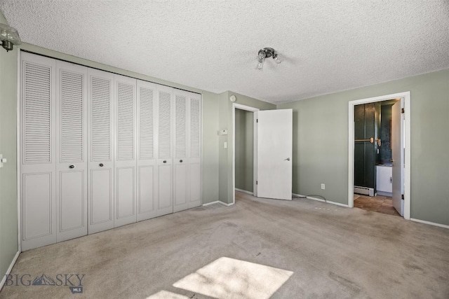 34 Mammoth, Butte, MT 59701 - unfurnished bedroom featuring carpet flooring, a baseboard radiator, a textured ceiling, baseboards, and a closet