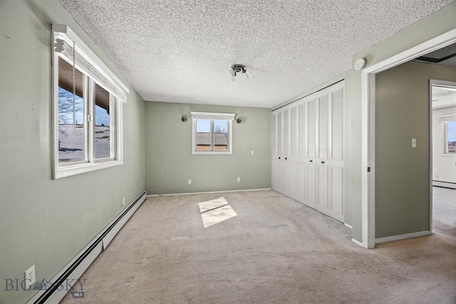 34 Mammoth, Butte, MT 59701 - unfurnished bedroom with a baseboard radiator, carpet flooring, a closet, baseboards, and a textured ceiling