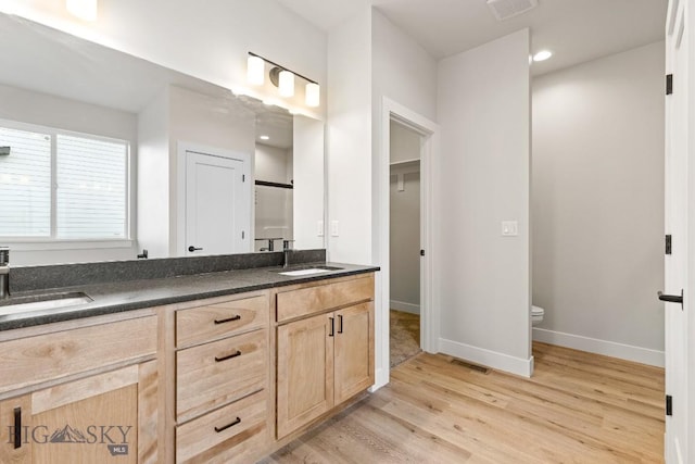 608 Spaniel Ln, Belgrade, MT 59714 - bathroom with wood finished floors, toilet, baseboards, double vanity, and recessed lighting