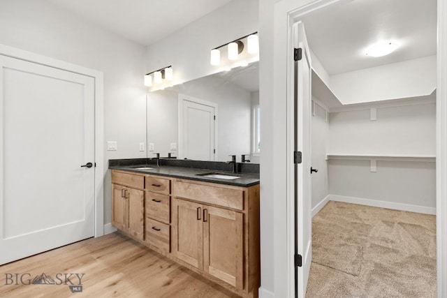 608 Spaniel Ln, Belgrade, MT 59714 - bathroom with double vanity, baseboards, and wood finished floors