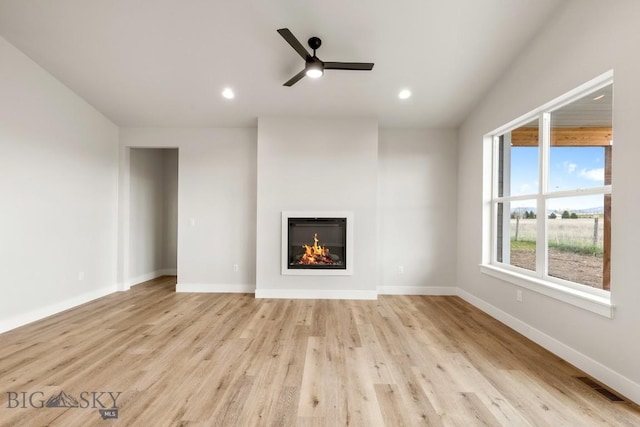 608 Spaniel Ln, Belgrade, MT 59714 - unfurnished living room featuring ceiling fan, a glass covered fireplace, light wood-style flooring, baseboards, and recessed lighting