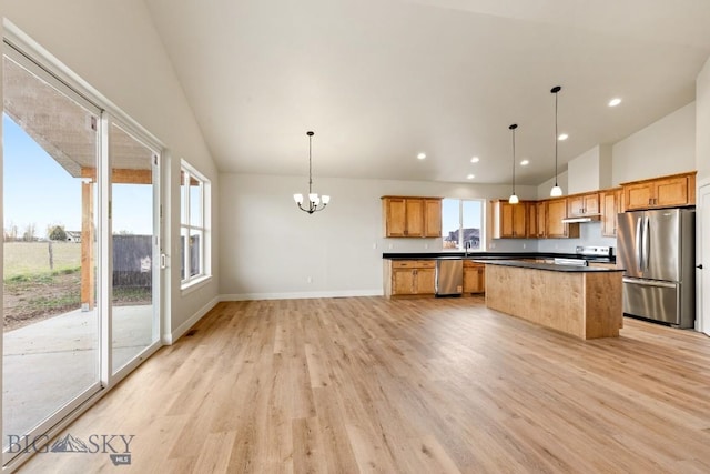 608 Spaniel Ln, Belgrade, MT 59714 - kitchen featuring stainless steel appliances, light wood finished floors, dark countertops, a kitchen island, and a chandelier