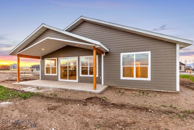 608 Spaniel Ln, Belgrade, MT 59714 - back of house at dusk featuring a patio area
