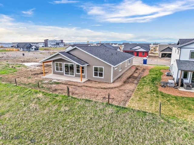 608 Spaniel Ln, Belgrade, MT 59714 - rear view of property featuring a patio area, roof with shingles, a lawn, and a residential view