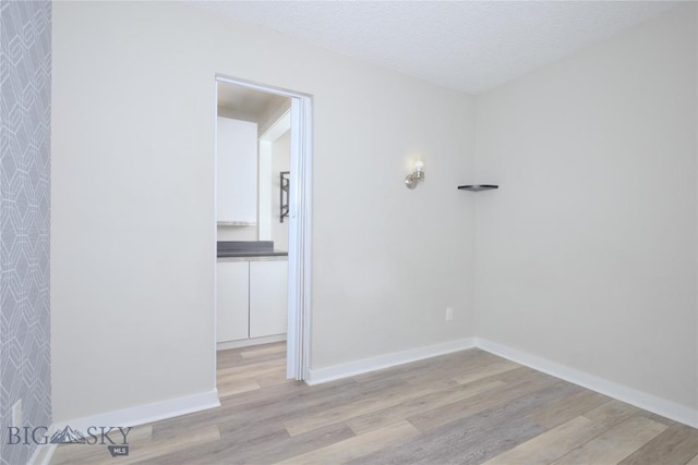 21 Sitting Bull Rd Unit 1226, Big Sky, MT 59716 - spare room with wood finished floors, baseboards, and a textured ceiling