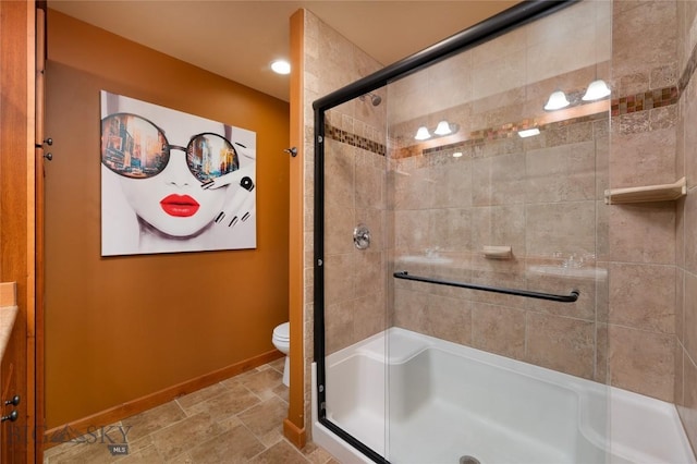 1079 N Cottonwood Rd, Bozeman, MT 59718 - bathroom featuring a shower stall, baseboards, toilet, stone finish floors, and vanity