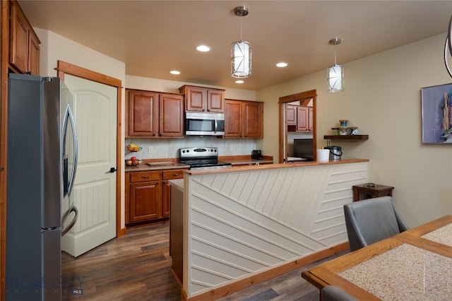 1079 N Cottonwood Rd, Bozeman, MT 59718 - kitchen featuring appliances with stainless steel finishes, dark wood-type flooring, brown cabinets, recessed lighting, and backsplash