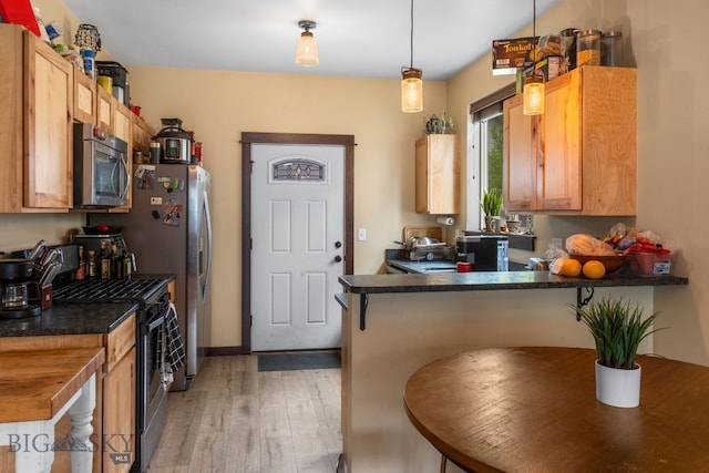 2472 Milkhouse Ave, Bozeman, MT 59718 - kitchen with stainless steel microwave, gas range oven, light wood-style floors, dark countertops, and a peninsula