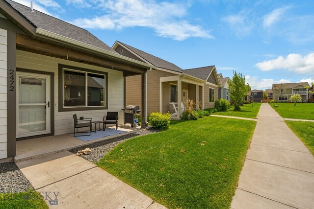 2472 Milkhouse Ave, Bozeman, MT 59718 - view of home's exterior with covered porch, a lawn, a residential view, and a shingled roof