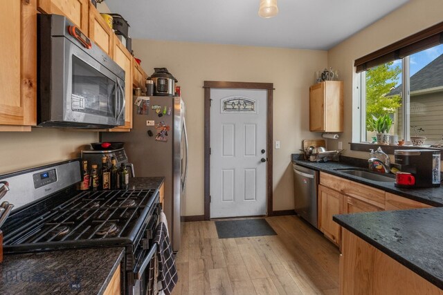 2472 Milkhouse Ave, Bozeman, MT 59718 - kitchen with stainless steel appliances, a sink, light wood-type flooring, and dark stone countertops