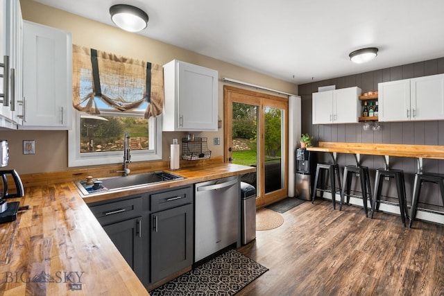 22 Rocky Mountain Dr, Whitehall, MT 59759 - kitchen featuring butcher block countertops, stainless steel dishwasher, a sink, dark wood-type flooring, and white cabinets